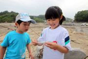 Миэ Инагава держит в руках возвращённую фотографию. Рядом её младший брат Котаро. 10-е июня 2011 г.